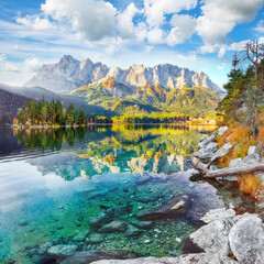 Amazing autumn landscape of Eibsee Lake in front of Zugspitze summit under sunlight.