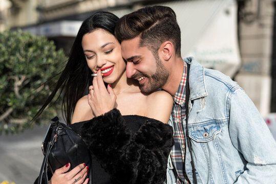 Young couple in outdoors image having fun in the city parks and street smoking