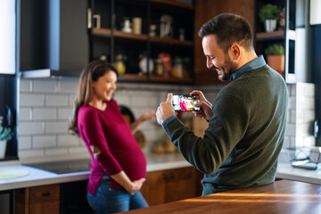 Happy couple cuddle at home make video call to friends, family members. Communicating online via app