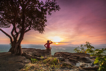 Young woman hiking on high mountain with beautiful sunset on Pha Daeng viewpoint, Na Yung Nam Som National park, Udon-Thani province , Thailand.