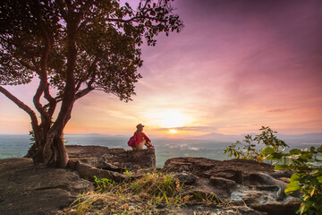 Young woman hiking on high mountain with beautiful sunset on Pha Daeng viewpoint, Na Yung Nam Som National park, Udon-Thani province , Thailand.