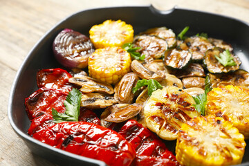Delicious grilled vegetables, mushrooms and parsley in pan on table, closeup