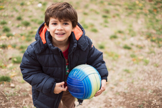 four years old little kid with ball looking at camera