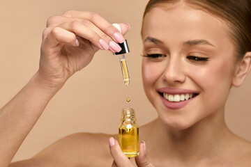Portrait of woman applying serum for skincare routine in studio, focusing on beauty and healthy...