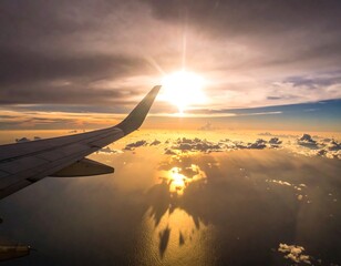 Plane wing over clouds reflecting sunlight on the sea, seen during a flight journey against sunset