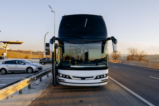Reflective bus front at sunset revealing boarding area