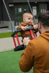 Father and Baby Enjoying Swing Time.