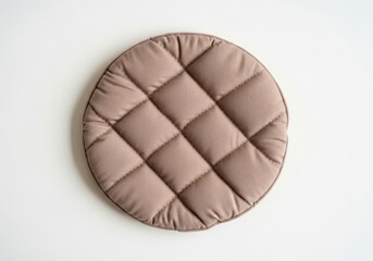 Naklejka premium Round quilted seat cushion rests centrally upon a plain white surface viewed from directly above.