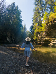 Woman Strolling by River in Forest Copy Space