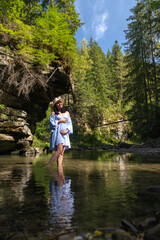 Pregnant Woman Enjoying a Tranquil Forest Stream