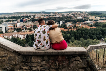 A couple embracing on a hill overlooking the city of Cluj-Napoca in Romania.