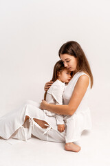 a newborn baby in its mother's arms, the mother soothes the baby before bedtime by rocking it to sleep