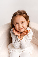 a girl child on a white cyclorama background, a girl in a white suit, a portrait, and space for text