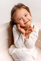 a girl child on a white cyclorama background, a girl in a white suit, a portrait, and space for text