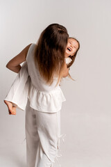 mother and child girl on a white cyclorama background, mother and daughter in a white suit hugging and kissing while playing, portrait, place and space for text