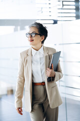 Fototapeta premium Elderly business woman walking in the hall of business center