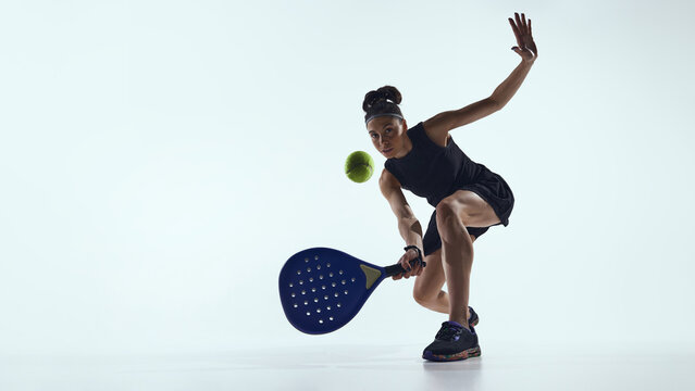 Female padel player controlling ball close to racket in studio. Concept of digital precision tools, feedback systems, data driven control and padel performance technology. - Powered by Adobe