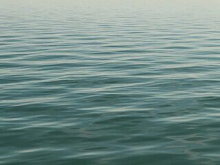 Calm ocean waves gently ripple on a serene sea surface at dawn