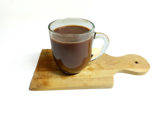 A comforting cup of rich hot chocolate served in a clear glass mug on a rustic wooden board, perfect for a cozy moment or a winter treat