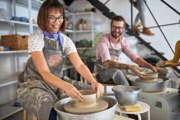 Teacher showing how to make handmade pot from clay on  wheel. Creative, hobby ,workshop  concept
