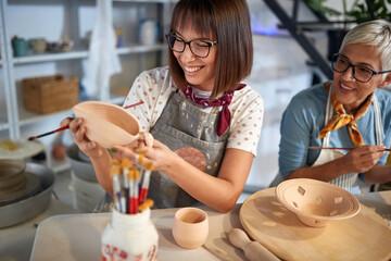woman artist designing a pot on pottery workshop. Creative, hobby ,activities concept
