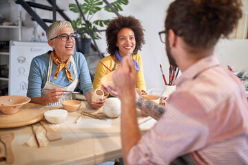 Teacher and students designing pot from clay on pottery workshop. Creative, hobby ,activities concept