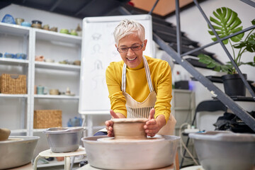 Elderly woman enjoying in her pottery making hobby. Creative, hobby ,workshop  concept