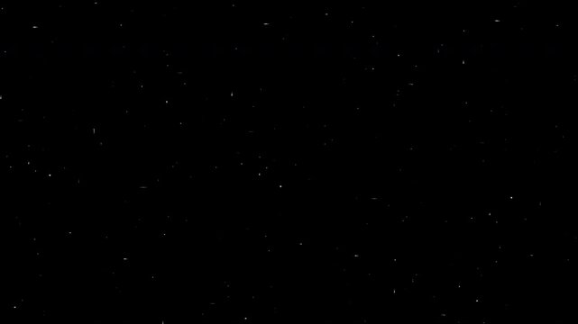 Dust particles floating in the air against a black background, creating a subtle and ethereal visual effect.