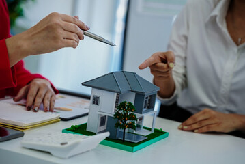 A real estate agent explained the insurance policy to a couple buying a new home, highlighting key terms and future investment during a meeting.