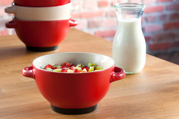 Red Bowl of Fresh Fruit Salad with Milk Carafe