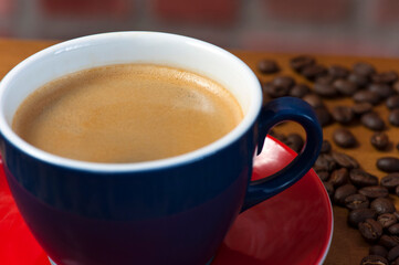 Blue Cup of Creamy Coffee on Red Saucer