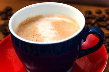 Cappuccino in Blue Cup on Red Saucer Close-Up