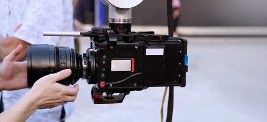 Behind the scenes of movie shooting or video production and film crew team with camera equipment at outdoor location. Video camera with professional robotic arm. BTS of Filming camera setup at outdoor