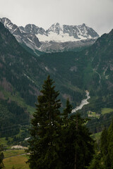 Obraz premium Scenic car driving on a winding mountain road through Adamello Regional Park in the Italian Alps during summer