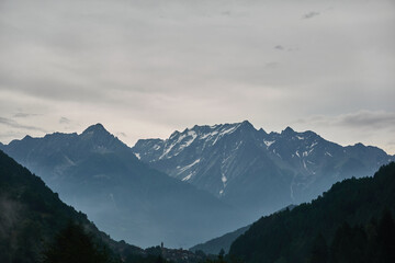 Scenic car driving on a winding mountain road through Adamello Regional Park in the Italian Alps during summer
