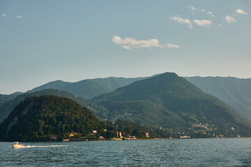 Obraz premium Picturesque landscape of Lake Como with luxury villas and colorful villages nestled against the Italian Alps under a blue sky