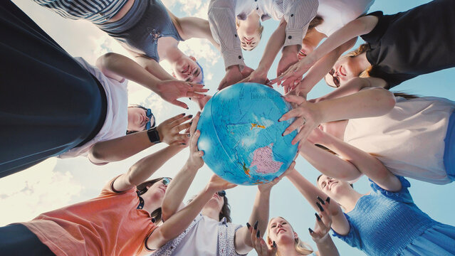School friends holding a globe together, symbolizing environmental protection and global unity