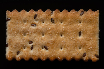 Cookies with seeds and sugar on a black background, top view