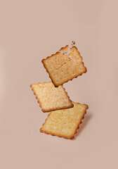 Cracker with crumbs on a beige background, space for text