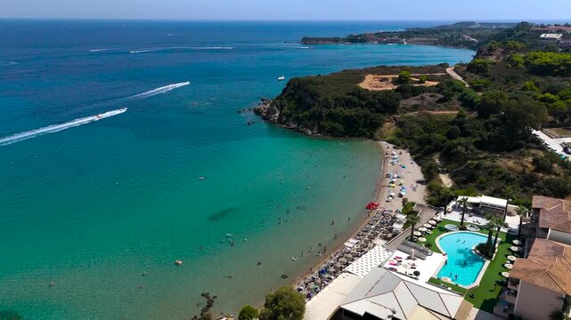 4K Cinematic Drone Footage of St Nicholas Beach in Zakynthos, Greece, Turquoise Shallow Bay, Beach Resort Facilities and Boats on the Ionian Sea