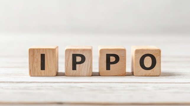 Wooden blocks spelling out the word IPPO arranged on a light wooden table surface in a minimalist setting for creative concept and design purposes