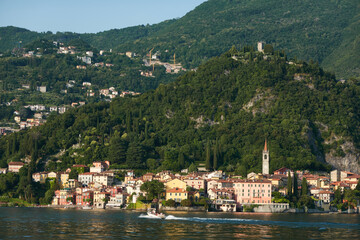 Fototapeta premium Picturesque landscape of Lake Como with luxury villas and colorful villages nestled against the Italian Alps under a blue sky