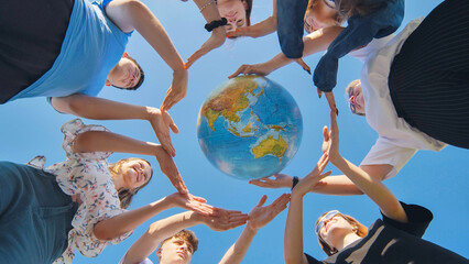 Students make a circle around the globe of the world. The concept of world peace.