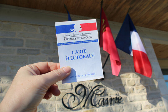 France - journ&eacute;e des &eacute;lections&nbsp;: main d'une femme tenant une carte d'&eacute;lecteur fran&ccedil;ais devant l'H&ocirc;tel de Ville, le jour des &eacute;lections