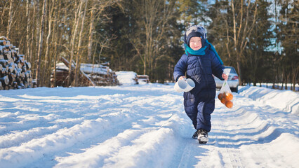 Young child traversing snow covered path, holding warm drinks, experiencing wintertime joy