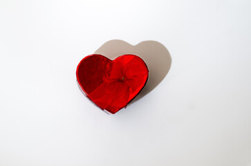 Fototapeta premium Red heart shaped gift box in center neutral background, hard dramatic shadow. horizontal minimalistic shot