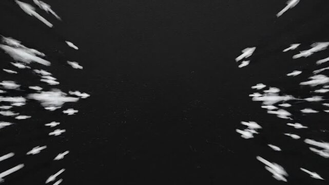 Thousands of tiny white arrows move quickly and unidirectionally across a dark screen