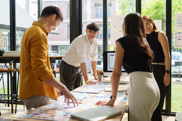 Group of UX UI designers analyzing interface mockups during a collaborative meeting.