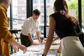 Group of UX UI designers analyzing interface mockups during a collaborative meeting.