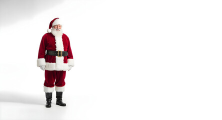 Caucasian man dressed as Santa Claus standing with hands in pockets on solid white background. Banner template for Christmas holiday concept with copy space.